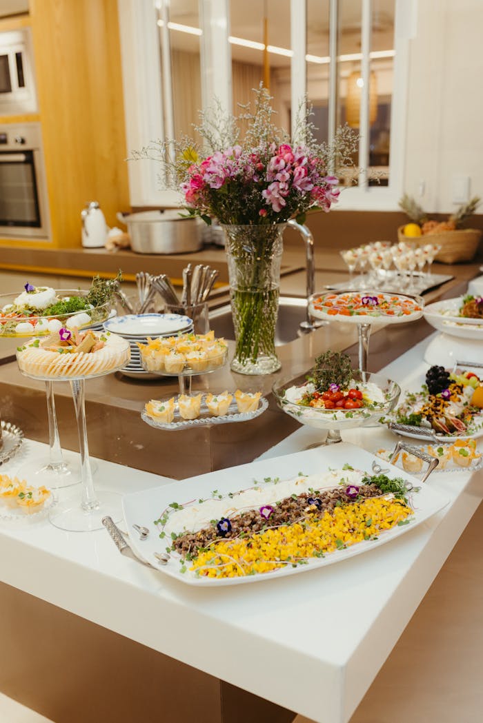 Luxurious buffet table with beautifully arranged dishes and vibrant floral centerpiece indoors.